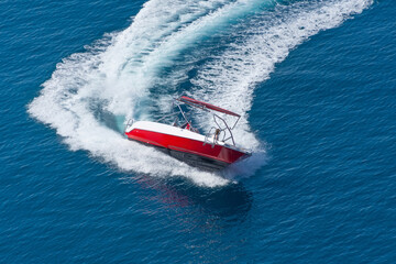 Aerial drone top boat making extreme manoeuvres in Mediterranean bay with deep blue sea.