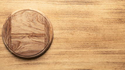 Empty round pizza board on wooden old background, top view