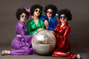Group of happy girls in disco style, with disco ball, halloween party, on gray background. 80s...