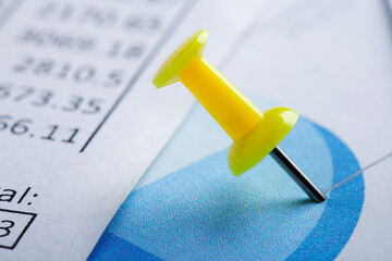 Marking financial chart by pins.Share listing and checking financial chart. Concept of banking, financial report and financial audit.