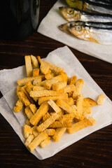 Beer snack salted white bread crackers close-up, fish and cold beer in glass bottle on dark background
