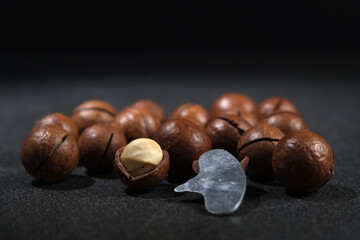 Macadamia nuts with a key on a black background.