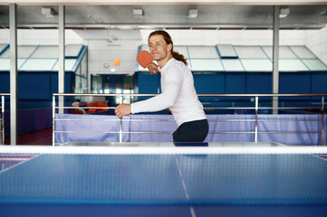 Portrait of young table tennis player training in sport club