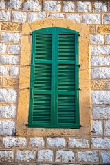 traditional green window blinds on an old Lebanese mountain stone house