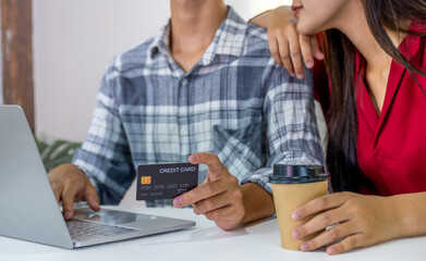 Young couple consumer hand holding mock up credit card, Ready to spend pay online shopping according to discount products via smartphone and laptop from home office