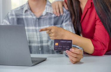 Young couple consumer hand holding mock up credit card, Ready to spend pay online shopping according to discount products via smartphone and laptop from home office