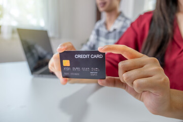 Young couple consumer hand holding mock up credit card, Ready to spend pay online shopping according to discount products via smartphone and laptop from home office