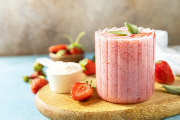 Fresh milk, strawberry drinks on wooden board on a stone background, protein shake with fresh...
