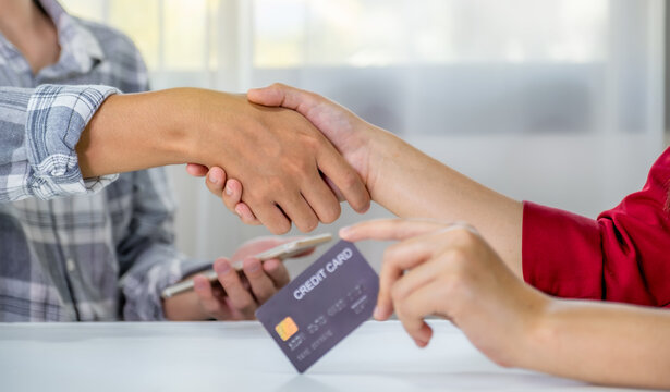 handshake. Young couple consumer holding mock up credit card, Ready to spend pay online shopping according to discount products via smartphone and laptop from home office - Powered by Adobe