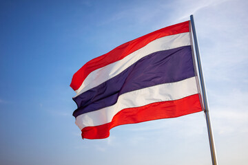 Fototapeta na wymiar A Thailand flag waving in the wind against a blue sky.