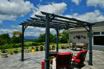 Fototapeta na wymiar Patio living space with comfortable seating around fire pit under pergola