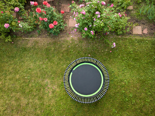 mini trampoline for fitness exercising and rebounding in a backyard, aerial view in summer