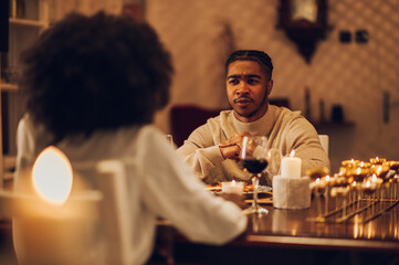 African american couple having romantic date and drinking wine at home