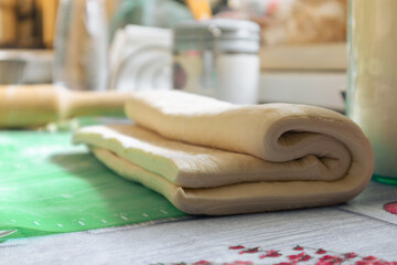 A piece of raw dough on the table. Dough ready for baking. Rolled sheet of dough