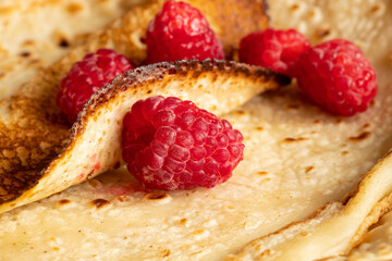 Thin pancakes with raspberries close-up, dessert