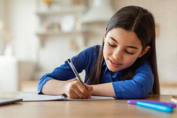 Arabic School Girl Writing Notes While Studying With Laptop Indoors