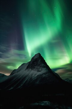 the aurora borealis gleams above a snowy mountain background. AI Generated