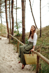 Delightful lady posing on wooden fence and smiling at camera