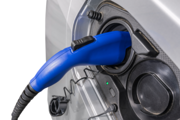 Close up of electric vehicle plug charging car isolated with cut out background.