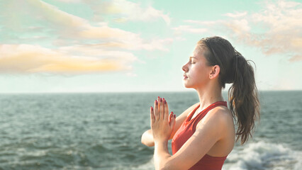 young woman exercises on the beach by the ocean
