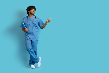 Cheerful young indian man in medical workwear doctor, copy space