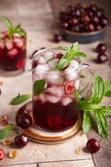 Lemonade with cherries, ice cubes, and mint. Refreshing cold spring and summer fruit or berry juicy beverage.