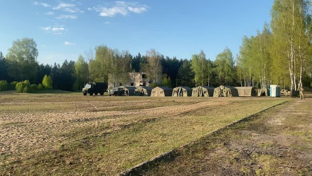 camouflage tents with truck isolated stand by forest in summer. Military base camp for exercise for young soldiers. Training and army lifestyle