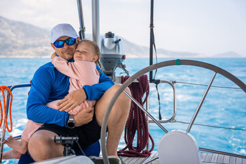 Father and daughter control sailing boat in the sea on boat or yacht. Family, adventure and skipper...
