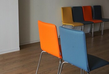 Reihen Stühle mit buntem Lederbezug in Raum in Altenpflegeheim