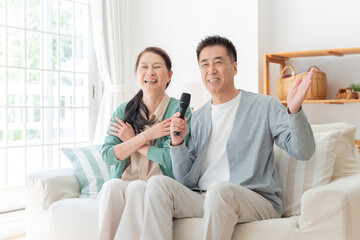 家でカラオケする高齢者夫婦