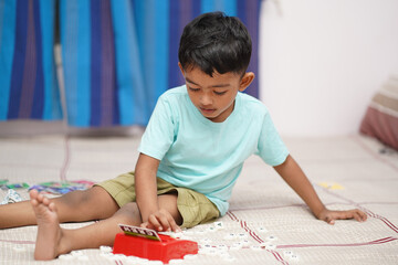 Attentive Young Toddler Boy with Red and White Scrabble Toy Alphabets, Attention-Kids Concept