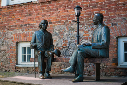 TARTU, Estonia - June 10, 2023: Bronze statues of Irish writer Oscar Wilde and Eduard Wilde sitting on a bench. History of literature.
