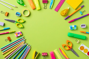 Back to school concept. Creative layout with school supplies on green background.