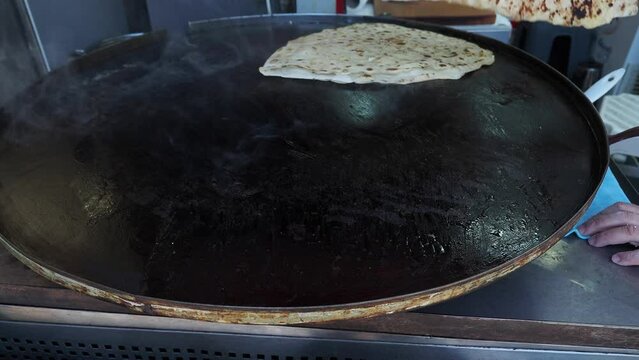  cooking roti chapati on a big cooking pan 