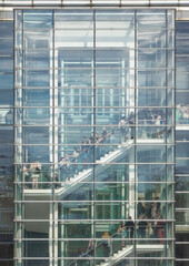 Fototapeta na wymiar Glass skyscraper office staircase full of people queueing in line on the stairs
