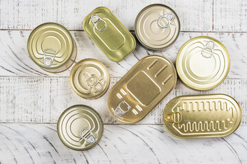 Closed tin silver cans. Tinned food on wooden background. Top view