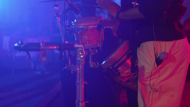 A man bangs his hands on the drums at a party or concert. A video without a face