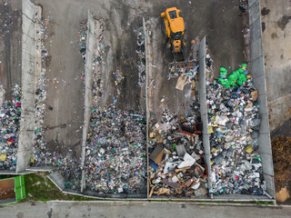 Process of moving a pile of waste with heavy equipment, wheel loader at the landfill site, aerial...