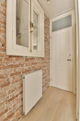 an empty room with brick walls and wood flooring on the wall, there is a white radiag