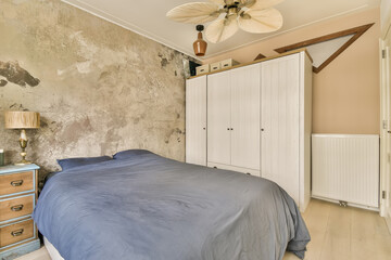 a bedroom with a bed, dressers and a ceiling fan in the middle of the room that is dirty