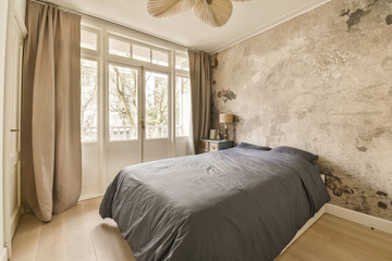 a bedroom with a bed and wallpaper on the walls in an apartment near paris, where there is no one