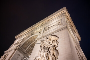 Detailed view of Arc de Triomphe from bottom by night, Paris, France