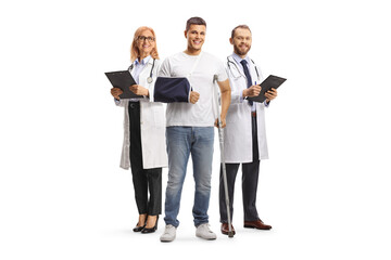 Young man with crutches and arm sling standing in front of a team of doctors
