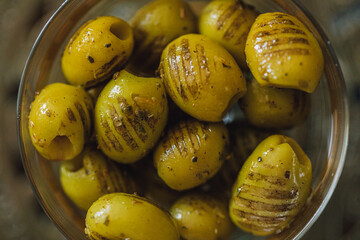 close up of cup full of grilled greek olives with oregano