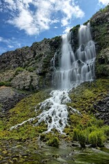 Waterfall under a blue sky in Idaho.