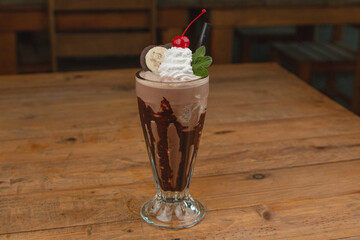 Chocolate mint milkshake, with chocolate, coffee, espresso, caramel, topped with whipped cream, a cherry, and chocolate cookies.




