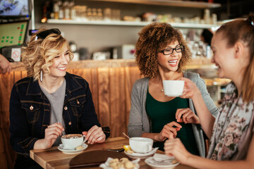 Small group of female friends enjoying a coffee in a cafe