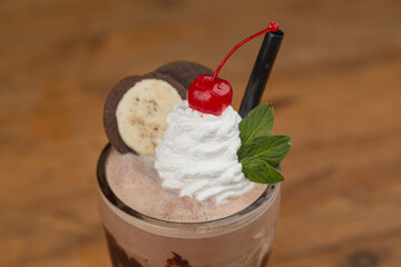 Chocolate mint milkshake, with chocolate, coffee, espresso, caramel, topped with whipped cream, a cherry, and chocolate cookies.




