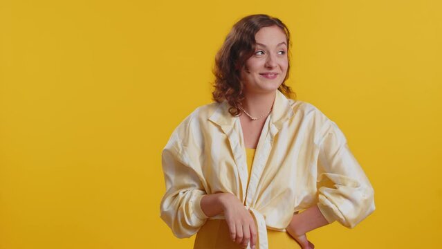 You are crazy, out of mind. Displeased woman pointing at camera, show stupid gesture finger near head, blaming some idiot for dumb insane plan idea, senseless talk. Girl isolated on yellow background