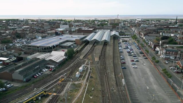 Southport, Lancashire, UK, June 19, 2023; Mid-level aerial fly uo clip video footage of the train and railway station in Southport, England